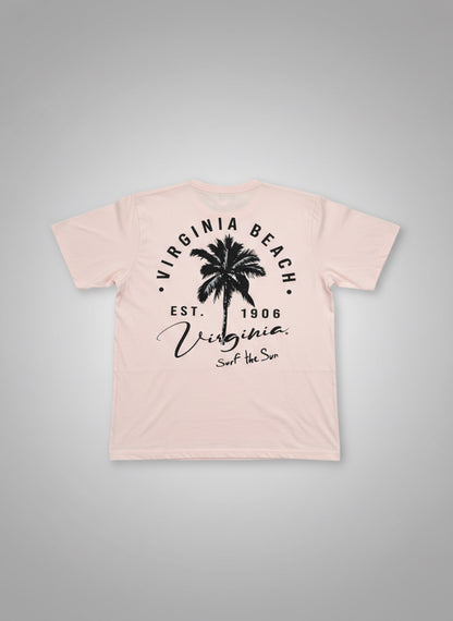 Pink t-shirt with black palm tree design and text on a gray background