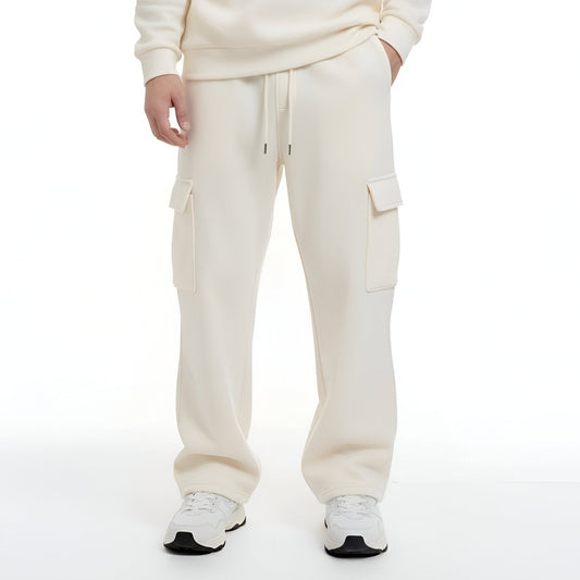 Person wearing a cream-colored hoodie and pants set on a white background