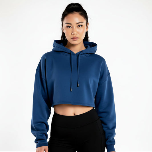 Woman wearing a blue cropped hoodie and black shorts on a white background
