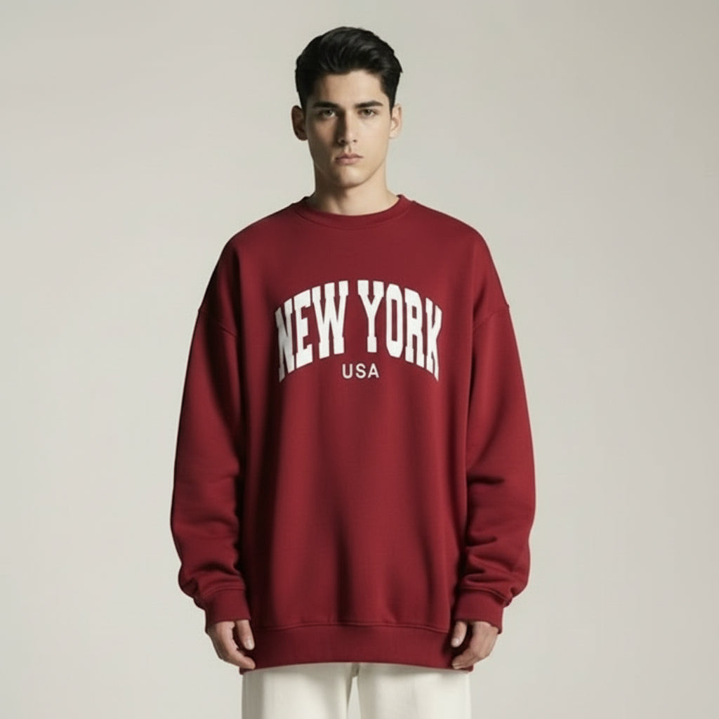 Person wearing a red sweatshirt with 'New York USA' text on a plain background