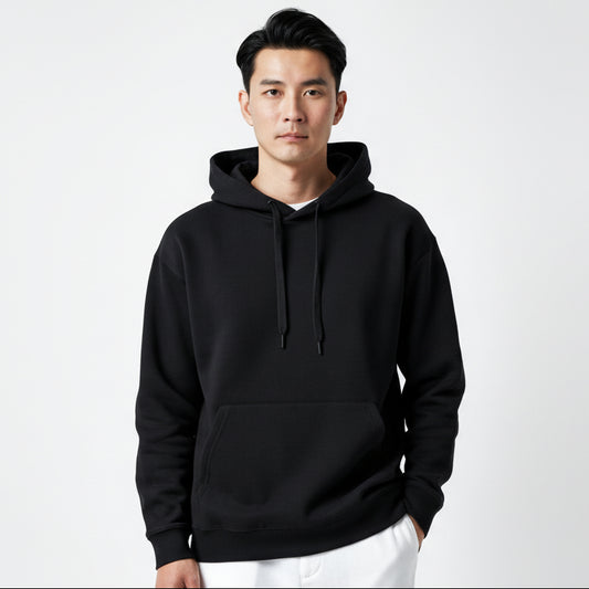 Man wearing a black hoodie and white pants on a light gray background